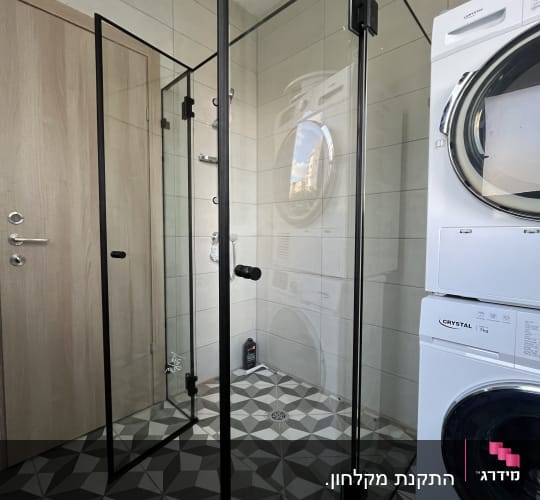 מקלחון זכוכית בחדר אמבטיה עם מכונת כביסה
